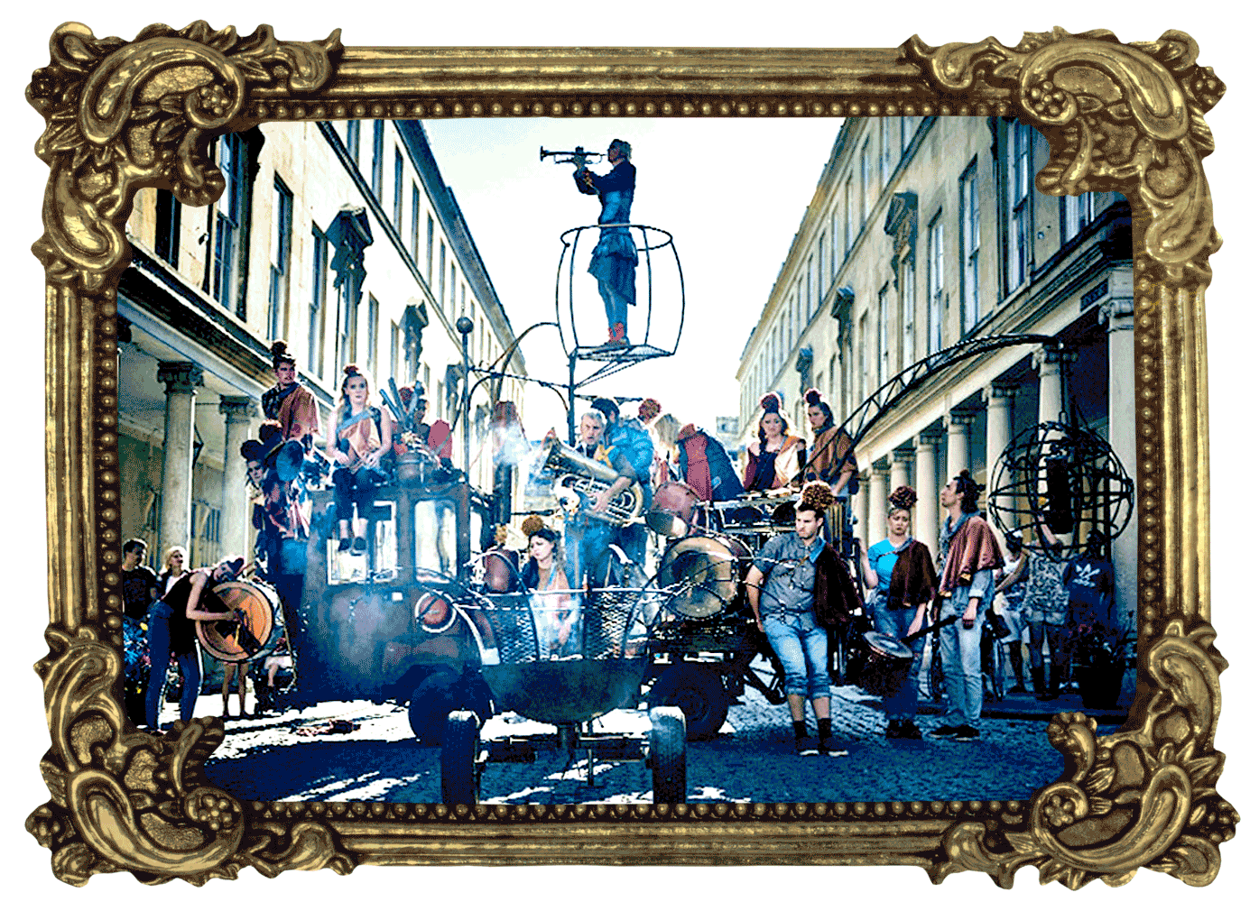 A large group of people dressed in denim with troubadour cloaks over one shoulder and large pom poms on their heads stand on and around a rust coloured, open-backed vehicle. Some carry brass instruments and drums. From a small crane at the rear dangles a metal globe on a chain and from the centre a raised platform holds someone playing a trumpet. In the foreground, smoke smoulders from a large firepit on wheels.